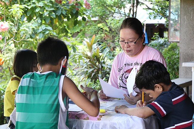 (Mama Malou tutoring her children. Their family welcomed four new children this year, a group of siblings who formerly stayed in a temporary shelter in Valenzuela.)